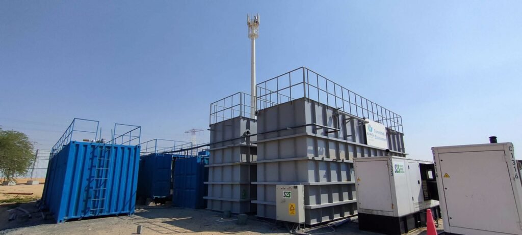 Modular container building in an industrial site with safety railings and external staircase, likely used as temporary offices or worker accommodations.