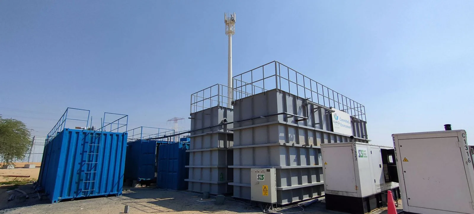 Modular container building in an industrial site with safety railings and external staircase, likely used as temporary offices or worker accommodations.
